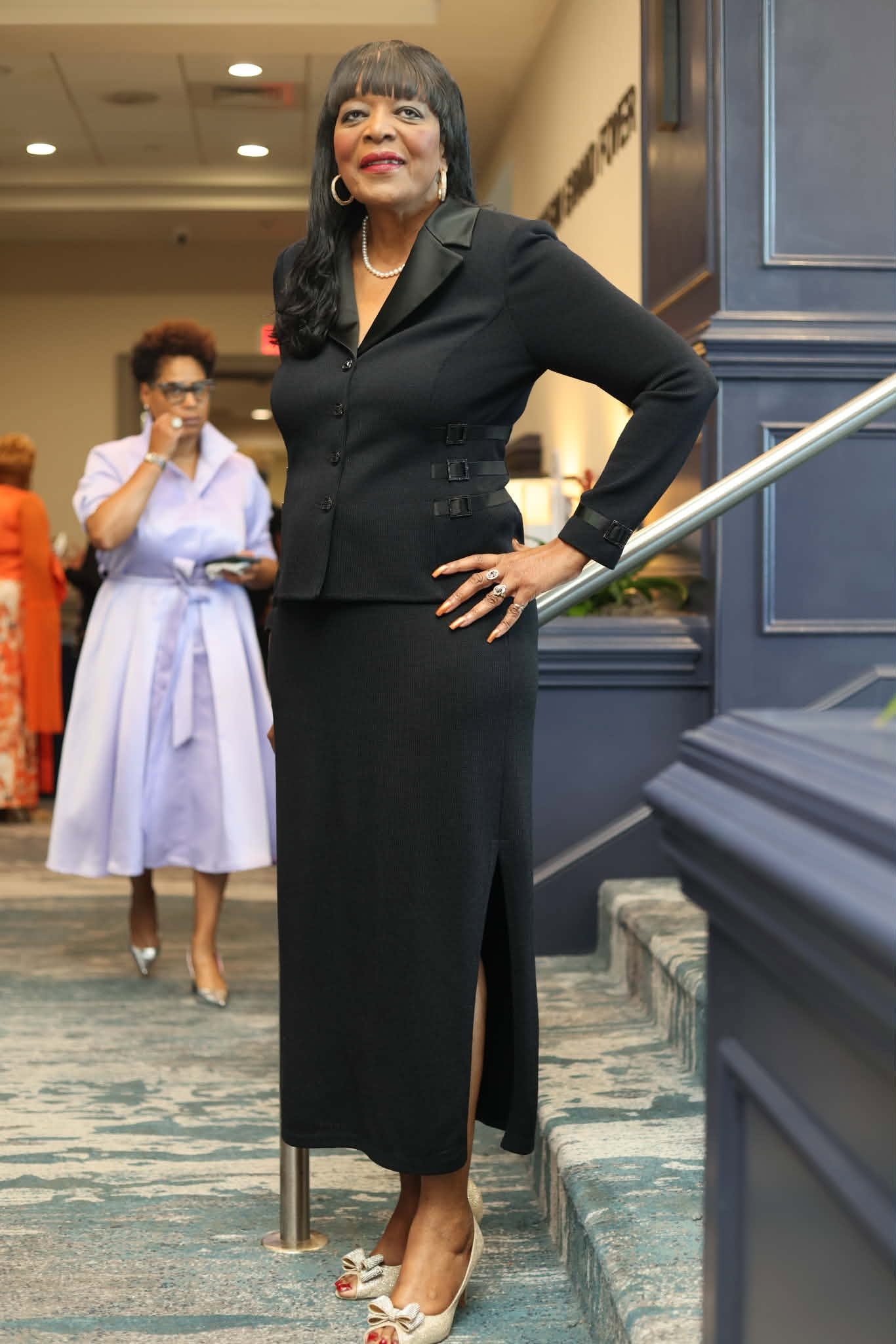 Elegantly Dressed Guest on the Sheraton Staircase